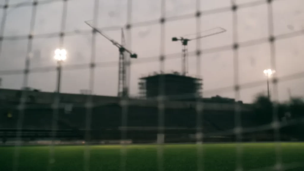 Court clears path for $325m White Stadium overhaul in Boston Dawn-lit empty stadium pitch, goal net in foreground, cranes blurred
