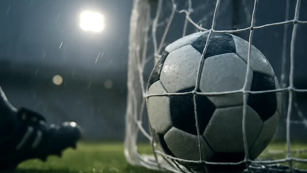 Stina Blackstenius: Sweden’s forward who finishes big moments Football resting in net on wet pitch under stadium floodlights.